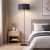 Nowoczesna lampa podłogowa w stylu minimalistycznym – elegancka, smukła forma i czarny klosz ze złotym wnętrzem tworzą wyjątkowy klimat. Idealna do sypialni, salonu i wnętrz modern. Designerskie oświetlenie łączące funkcjonalność z estetyką.