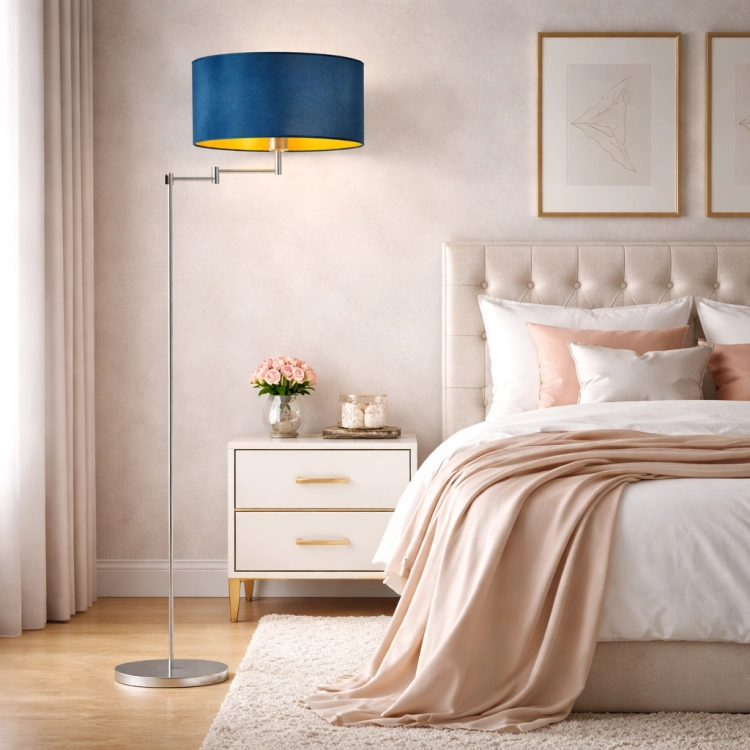 Elegancka lampa podłogowa w stylu glamour z granatowym welurowym abażurem i złotym wnętrzem doskonale uzupełnia luksusową sypialnię. Smukła, chromowana konstrukcja z regulowanym ramieniem łączy funkcjonalność z nowoczesnym designem.