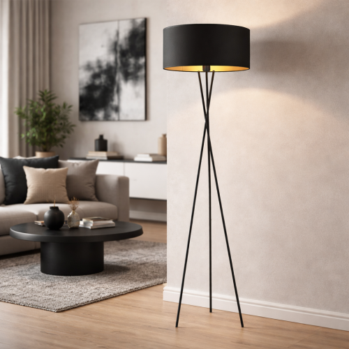 Nowoczesna lampa podłogowa na trójnogu do salonu. Czarny abażur ze złotym wnętrzem daje ciepłe światło i podkreśla minimalistyczny, elegancki charakter wnętrza.