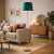 Nowoczesna lampa podłogowa ze złotą podstawą i zielonym abażurem idealnie dopełnia aranżację salonu w stylu mid-century. Designerska forma przyciąga uwagę, tworząc elegancki i przytulny klimat wnętrza.