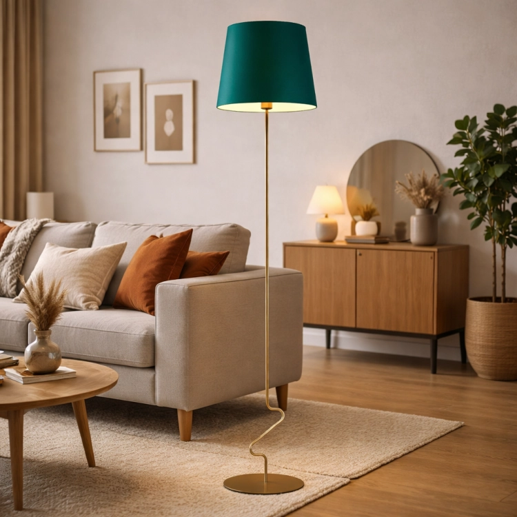 Nowoczesna lampa podłogowa ze złotą podstawą i zielonym abażurem idealnie dopełnia aranżację salonu w stylu mid-century. Designerska forma przyciąga uwagę, tworząc elegancki i przytulny klimat wnętrza.