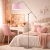 Stylowa lampa podłogowa z różowym abażurem w przytulnym pokoju nastolatki. Nowoczesny design łączy funkcjonalność z delikatną estetyką, tworząc ciepłą atmosferę idealną do nauki i relaksu. Doskonały wybór do modnych wnętrz młodzieżowych.