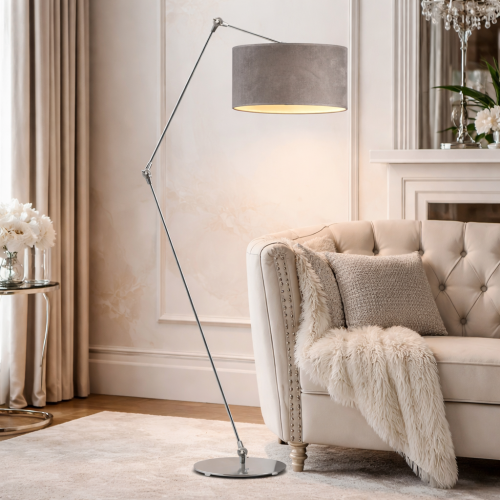Nowoczesna lampa podłogowa w stylu glamour z regulowanym ramieniem i eleganckim, szarym abażurem. Chromowana konstrukcja dodaje wnętrzu luksusu i lekkości. Idealna do salonu obok fotela, zapewnia stylowe oświetlenie i wyjątkowy klimat.