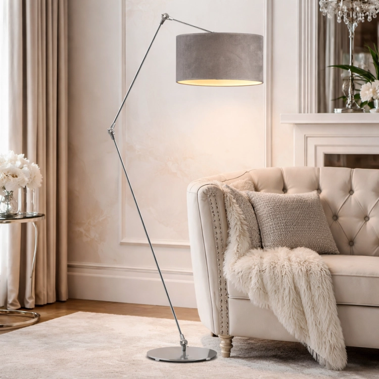 Nowoczesna lampa podłogowa w stylu glamour z regulowanym ramieniem i eleganckim, szarym abażurem. Chromowana konstrukcja dodaje wnętrzu luksusu i lekkości. Idealna do salonu obok fotela, zapewnia stylowe oświetlenie i wyjątkowy klimat.