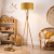 Stylowa lampa podłogowa na trójnogu w naturalnym wykończeniu drewna z eleganckim, musztardowym abażurem. Idealna do wnętrz boho i pokoju dziecięcego. Zapewnia ciepłe, przytulne światło i stanowi wyjątkowy element dekoracyjny.