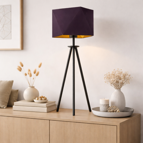 Nowoczesna lampka stołowa na trójnogu z geometrycznym kloszem w eleganckim, ciemnym kolorze to idealne uzupełnienie minimalistycznego salonu. Stylowa dekoracja na komodę, która łączy design, funkcjonalność i ciepłe, nastrojowe oświetlenie.