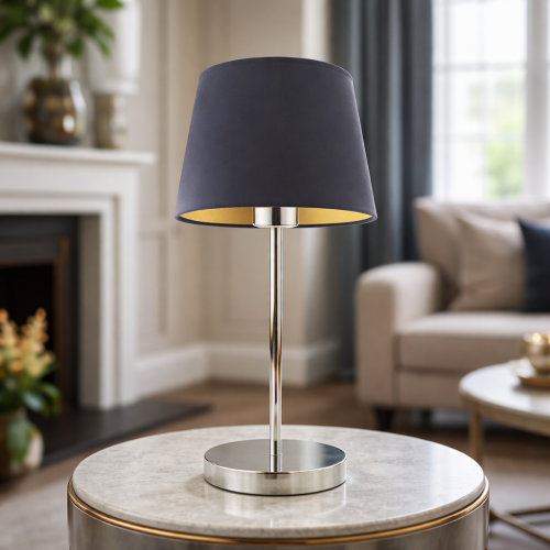 Elegancka lampka stołowa z granatowym abażurem i chromowaną podstawą idealnie dopełni nowoczesne wnętrze. Stylowy design, ciepłe światło i wysoka jakość wykonania sprawiają, że świetnie sprawdzi się w salonie lub sypialni.