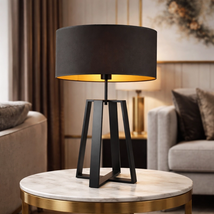 Elegancka lampa stołowa o nowoczesnym designie z geometryczną, czarną podstawą i stylowym abażurem. Idealna do salonu lub sypialni, tworzy ciepłe, przytulne światło. Doskonałe połączenie minimalizmu i luksusu z nutą złotych akcentów.