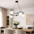 Nowoczesna lampa wisząca w stylu minimalistycznym z czarną metalową konstrukcją i mlecznymi, ryflowanymi kloszami. Designerska forma idealna do jadalni, salonu lub kuchni, łączy elegancję z funkcjonalnym, nastrojowym oświetleniem.