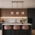Nowoczesna lampa wisząca nad wyspą kuchenną w stylu minimalistycznym. Eleganckie połączenie czerni, złota i szkła idealnie wpisuje się w modne wnętrza. Designerskie oświetlenie do kuchni, które podkreśla charakter aranżacji i tworzy przytulny klimat.