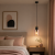 Nowoczesna lampa wisząca w stylu minimalistycznym idealnie komponuje się z przytulną sypialnią. Elegancki design, szklany klosz i ciepłe światło tworzą wyjątkowy klimat nad stolikiem nocnym. Doskonały wybór do wnętrz skandynawskich i modern.