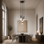 Nowoczesna lampa wisząca o minimalistycznym designie, idealna do wysokich wnętrz i eleganckich jadalni. Subtelne kuliste klosze i smukłe przewody tworzą efektowną kompozycję nad stołem, zapewniając stylowe i funkcjonalne oświetlenie.