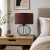 NESTLIGHT to designerska lampa stołowa z ażurową, metalową podstawą i eleganckim abażurem. Idealna jako lampa nocna do sypialni lub salonu. Zapewnia przytulne światło i podkreśla styl nowoczesny oraz loftowy